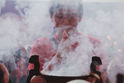 Man with hands clasped praying in temple