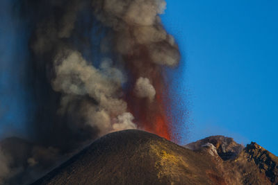 Volcanic eruption against blue sky