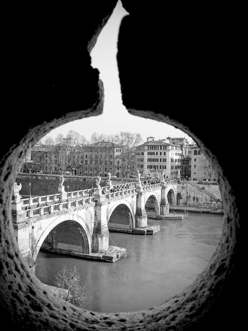 ARCH BRIDGE OVER RIVER DURING SUNSET