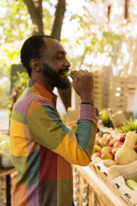 Side view of man drinking juice at home