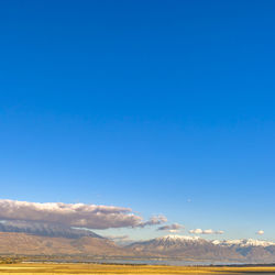 Scenic view of snowcapped mountains against blue sky