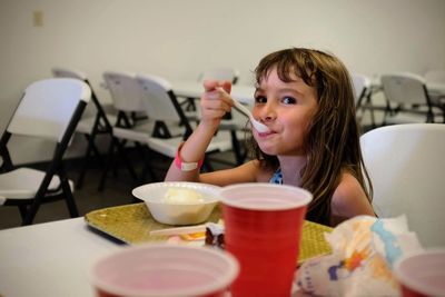 Portrait of girl having food at table in restaurant