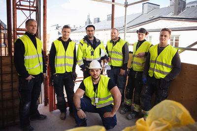 Portrait of confident professional workers posing at construction site