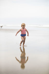 Girl running, laughing on the beach