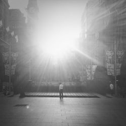 Sun shining through woman in city