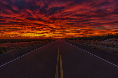 Empty road against sky during sunset