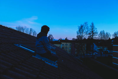 Woman standing against blue sky