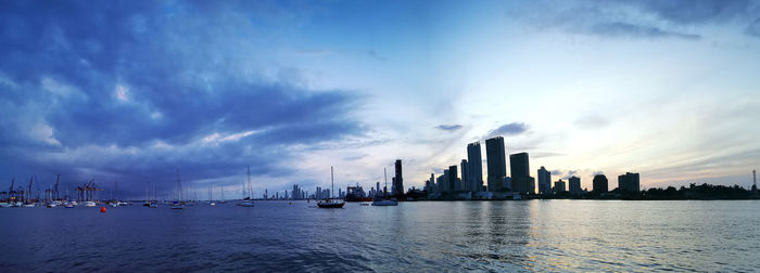 Panoramic view of city buildings against cloudy sky