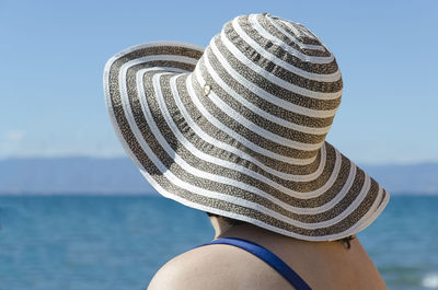 Close-up of woman wearing hat by sea