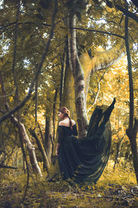 Woman with an elegant dress in the forest