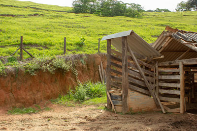 Wooden fence on field against trees