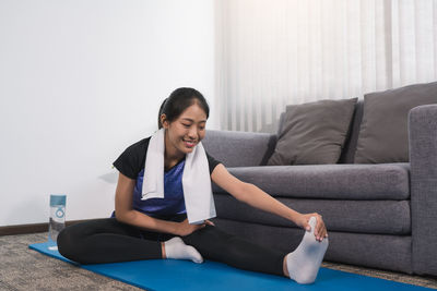 Portrait of young woman sitting on sofa at home