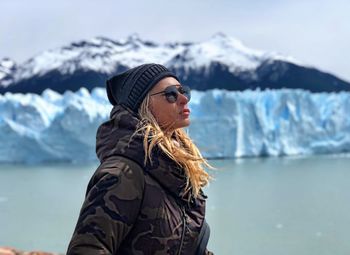 Mature woman wearing warm clothing while standing by sea during winter