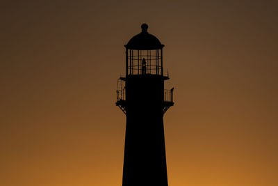 Silhouette of lighthouse against sky during sunset