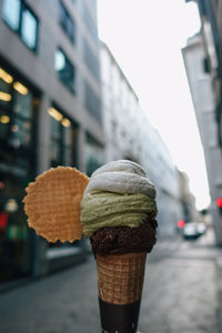 Close-up of ice cream cone against building in background