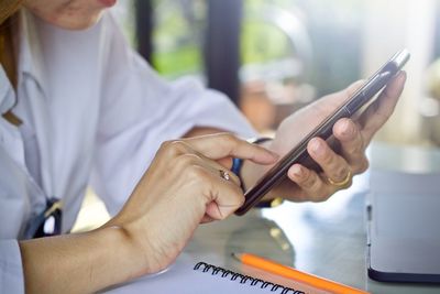 Midsection of woman using mobile phone