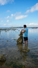 Full length of man standing on beach against sky