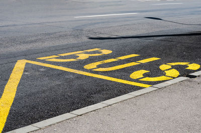 High angle view of yellow arrow sign on road