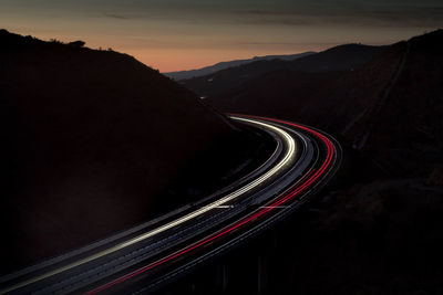 Light trails on road against sky at night