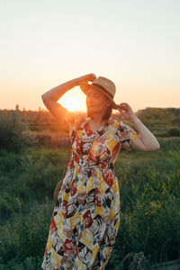 Rear view of woman wearing hat standing against sky