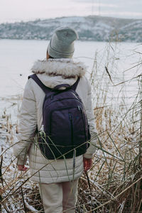 Rear view of man standing on snow covered land