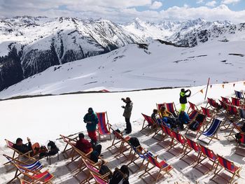 People on chairs at snow covered mountain