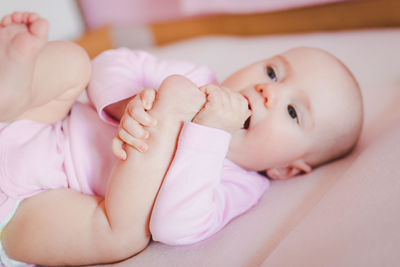 Close-up of baby lying on bed