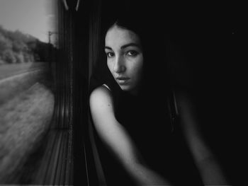Close-up of young woman looking through window