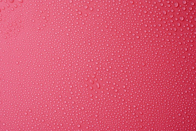 Full frame shot of water drops on pink background