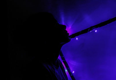 Low angle view of illuminated lighting equipment at night