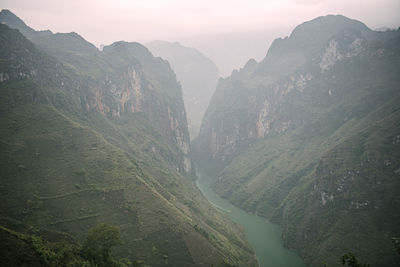 High angle view of valley and mountains against sky