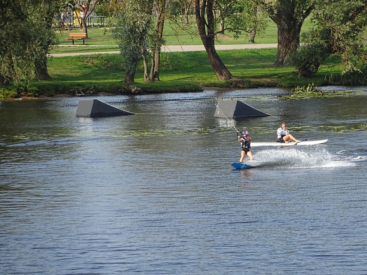 PEOPLE IN RIVER BY TREES