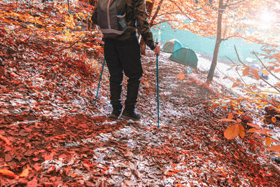 Low section of person standing on leaves during autumn