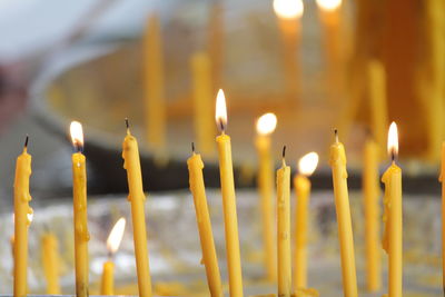 Close-up of illuminated candles in temple