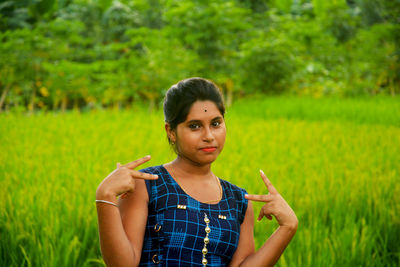 Portrait of young woman on field