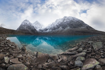 Scenic view of lake and snowcapped mountains against sky