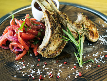 Close-up of lamb chop with rosemary on cutting board