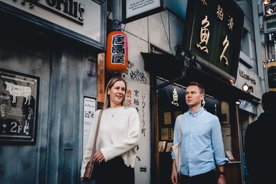 Young man standing by text on wall