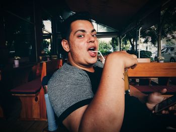 Portrait of man drinking while sitting in restaurant