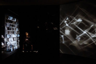 Reflection of woman on illuminated window at night