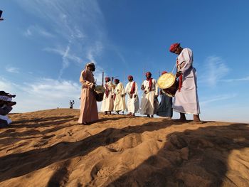 People standing on land against sky