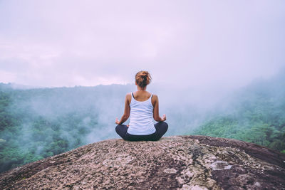 Full length of man sitting on seat against mountain