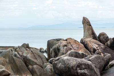 Rocks on beach against sky