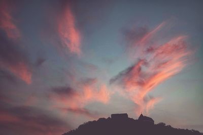 Low angle view of silhouette built structures against sky