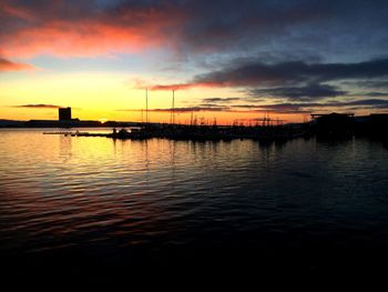 Scenic view of sea against cloudy sky at sunset