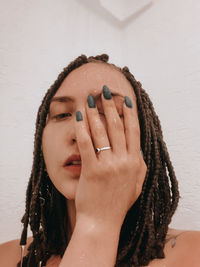 Portrait of young woman against wall