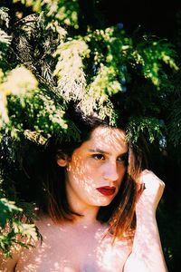 Portrait of young woman against trees