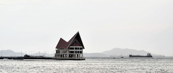 House on building by mountain against clear sky