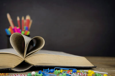 Love story book with open page of literature in heart shape and placed on the table, the background 