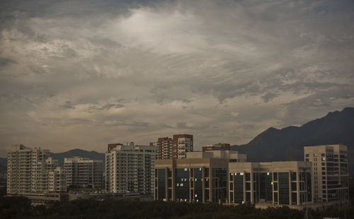 Buildings in city against sky at sunset